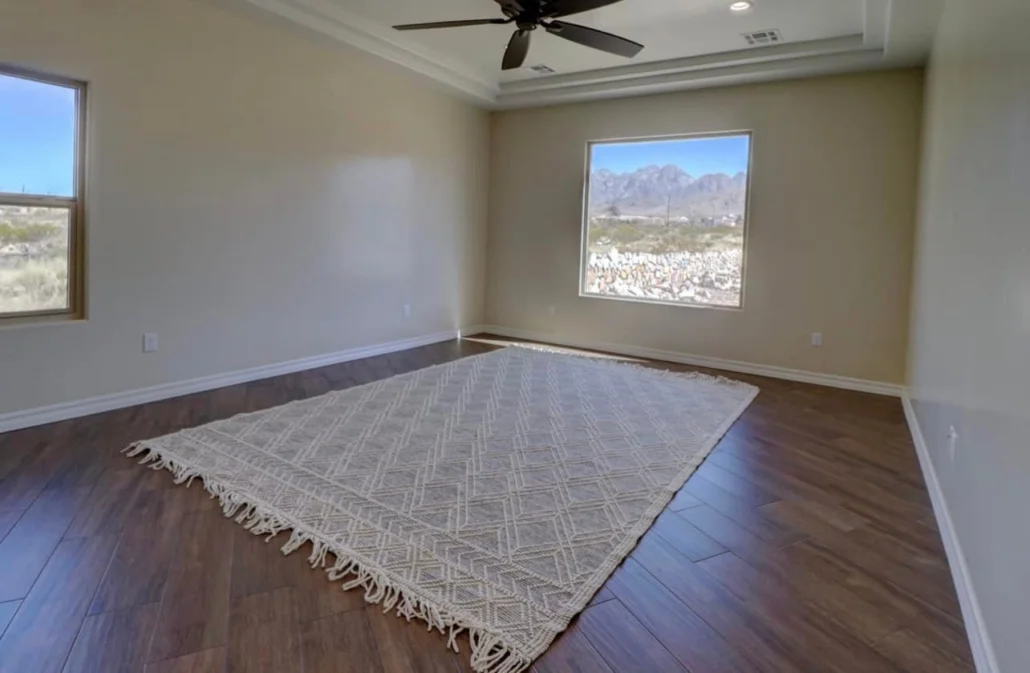 Bedroom with dark hardwood floors, coffered ceiling, and large windows with mountain views