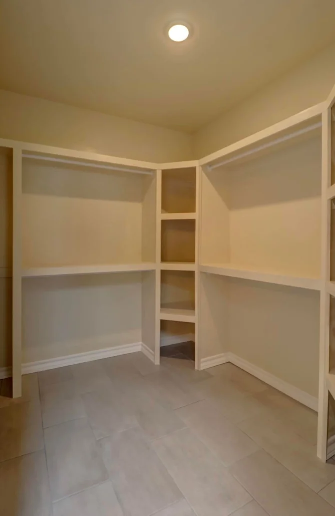 Walk-in closet with white built-in shelving, recessed lighting, and tile flooring