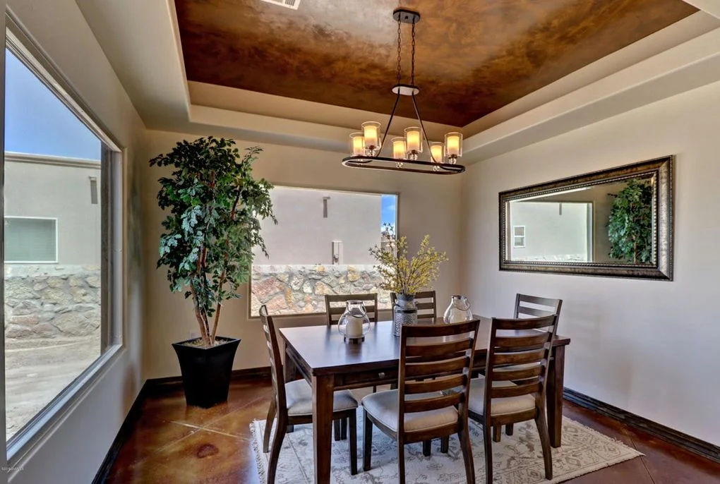 Dining room with faux-finished copper ceiling, coffered details, and polished concrete floors