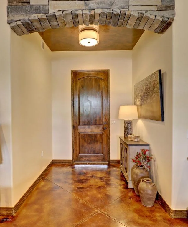Arched brick soffit entry with stained concrete floor and decorative scoring detail