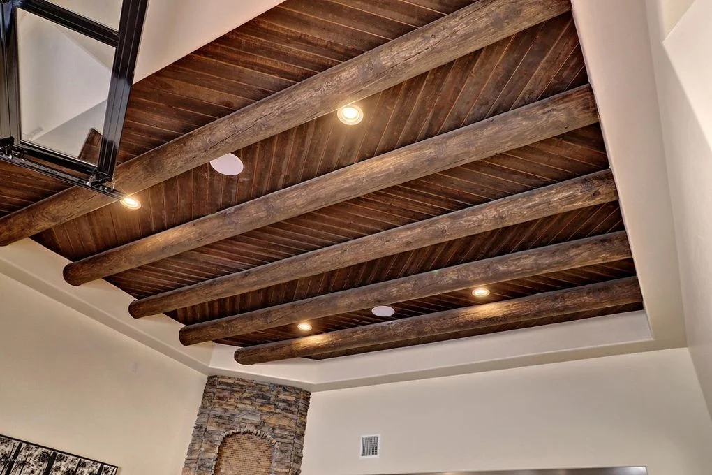 Dark stained timber beams in coffered ceiling pattern with recessed lighting and white drywall soffit
