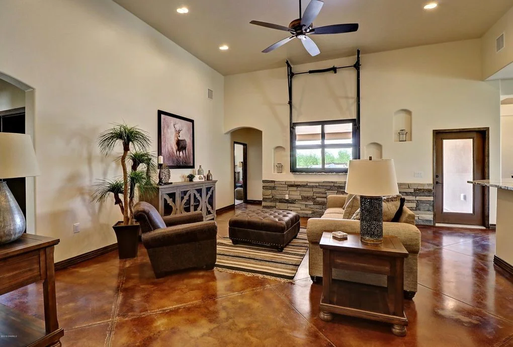 Family room with polished concrete floors, stone veneer wall, and coffered ceiling with recessed lights