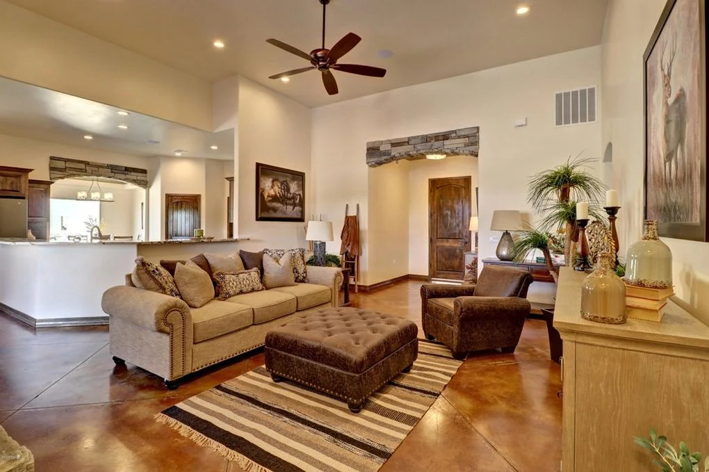 Open living room with polished concrete floors, custom wood trim, recessed lighting, and ceiling fan