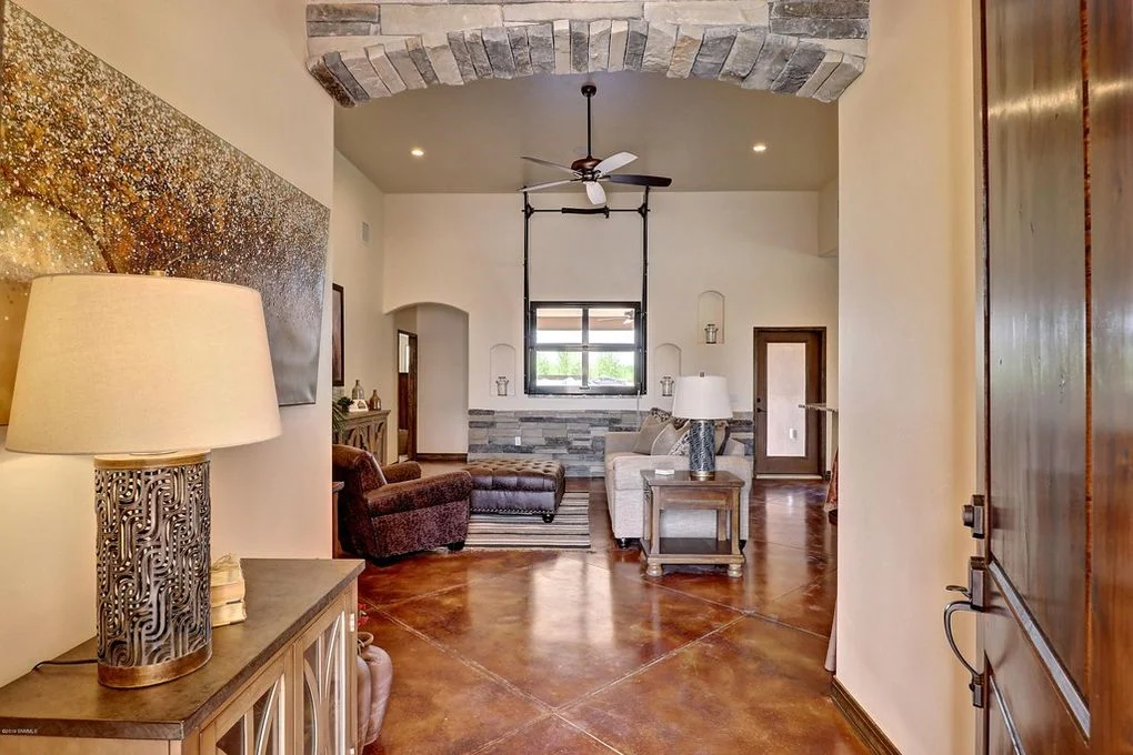 Foyer with arched brick soffit, polished concrete floors, and vaulted ceiling with custom woodwork