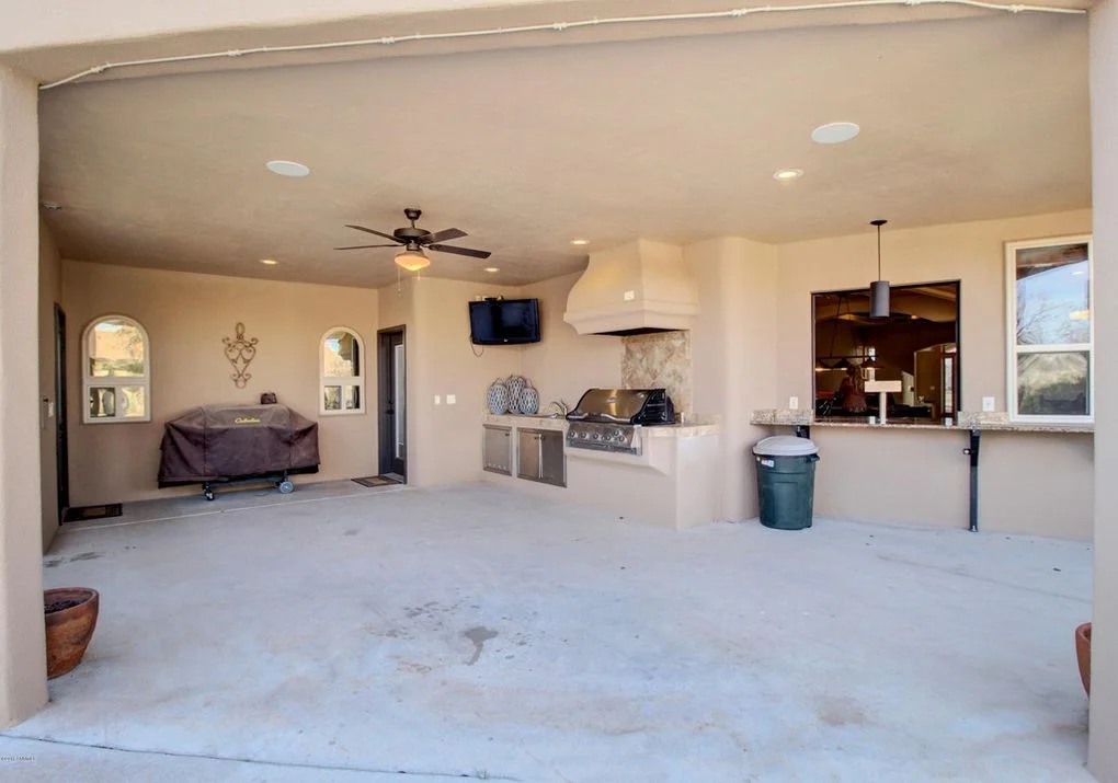 Covered patio with built-in kitchen, stainless steel grill, granite counters, and recessed lighting